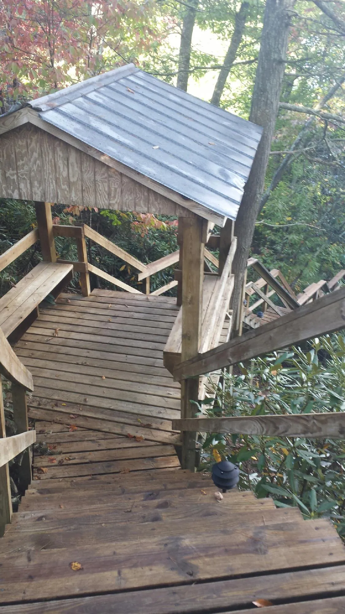 Metal roofed shelter over wooden steps on a wooded walkway — Skylight Repair & Installation work by our crew in Needham Heights