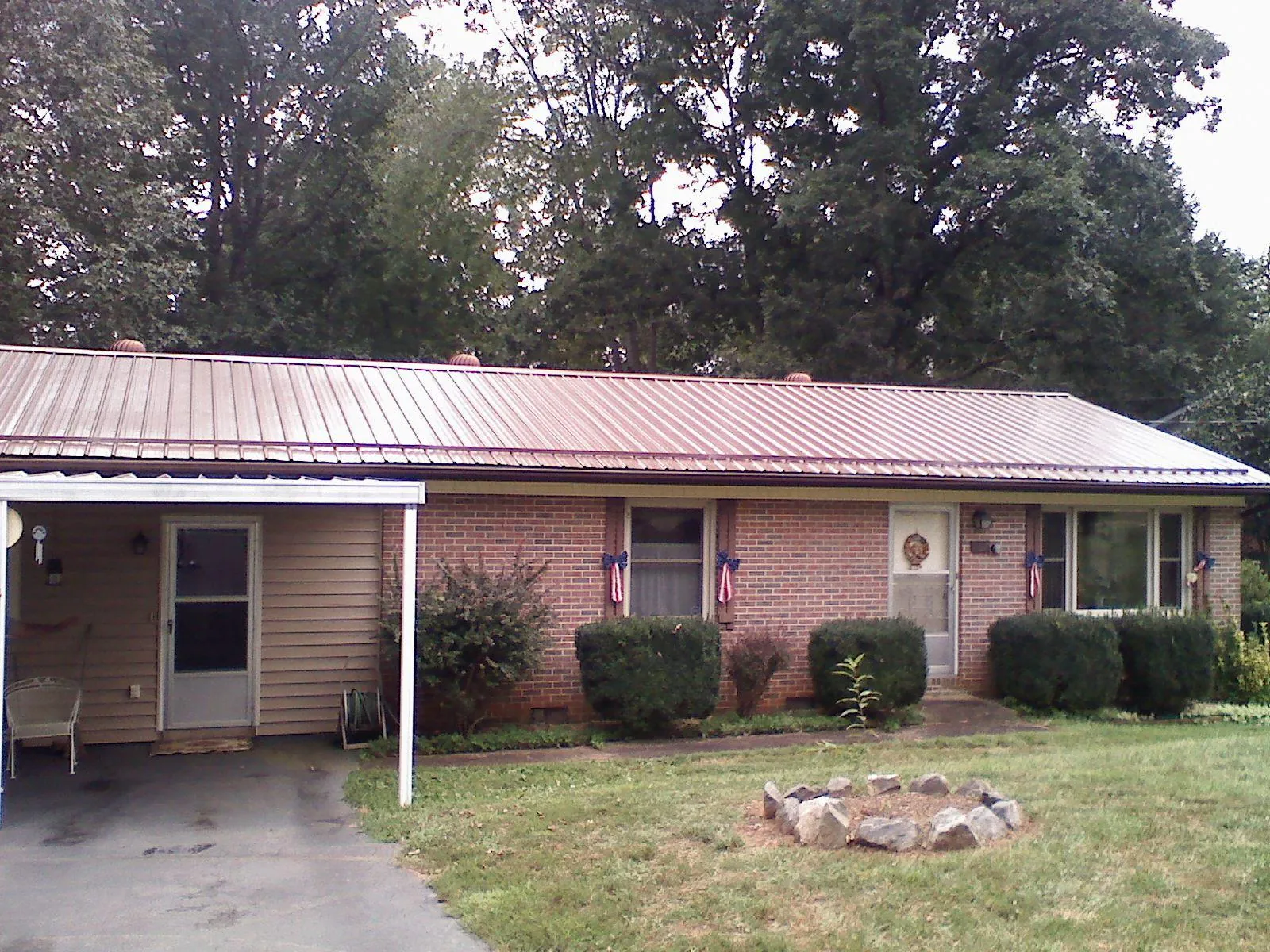 Bronze metal roof and carport on a brick ranch home — Roof Repair work by our crew in Needham Heights