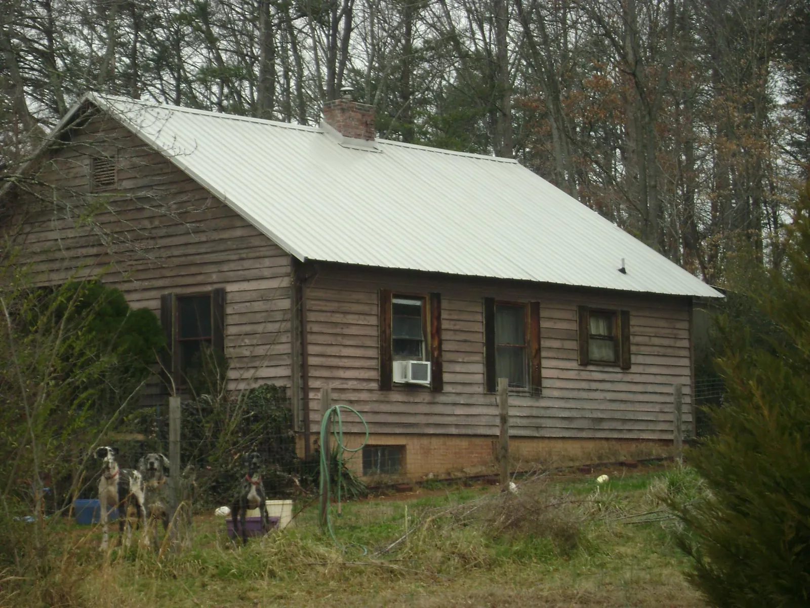 White metal roof on an old wood sided farmhouse, from a Metal Roof Installation job in Needham Heights